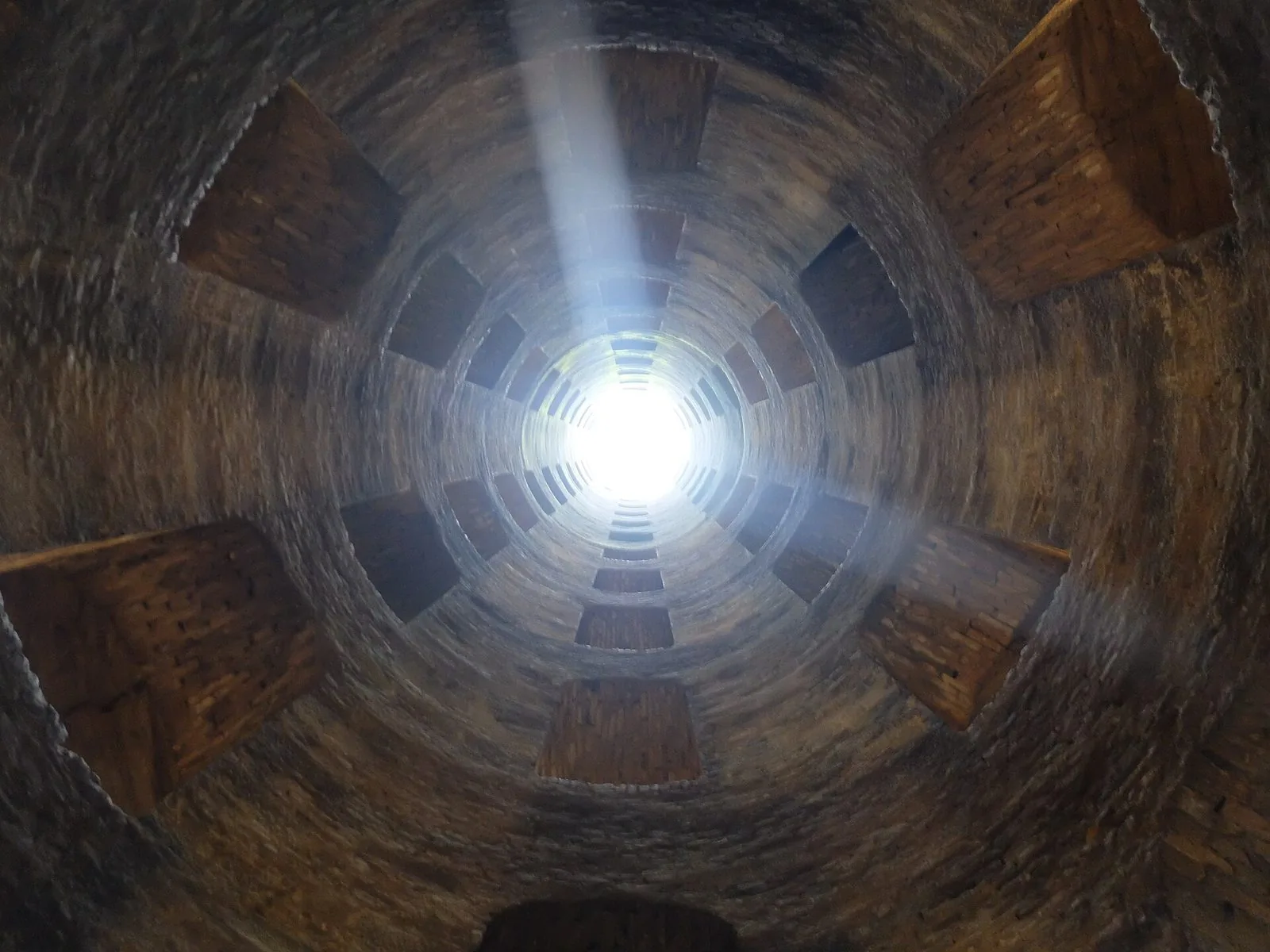 Il Pozzo di San Patrizio a Orvieto visto dal fondo: il cilindro in muratura con le finestre ad arco disposte a spirale e la luce che entra dall'alto