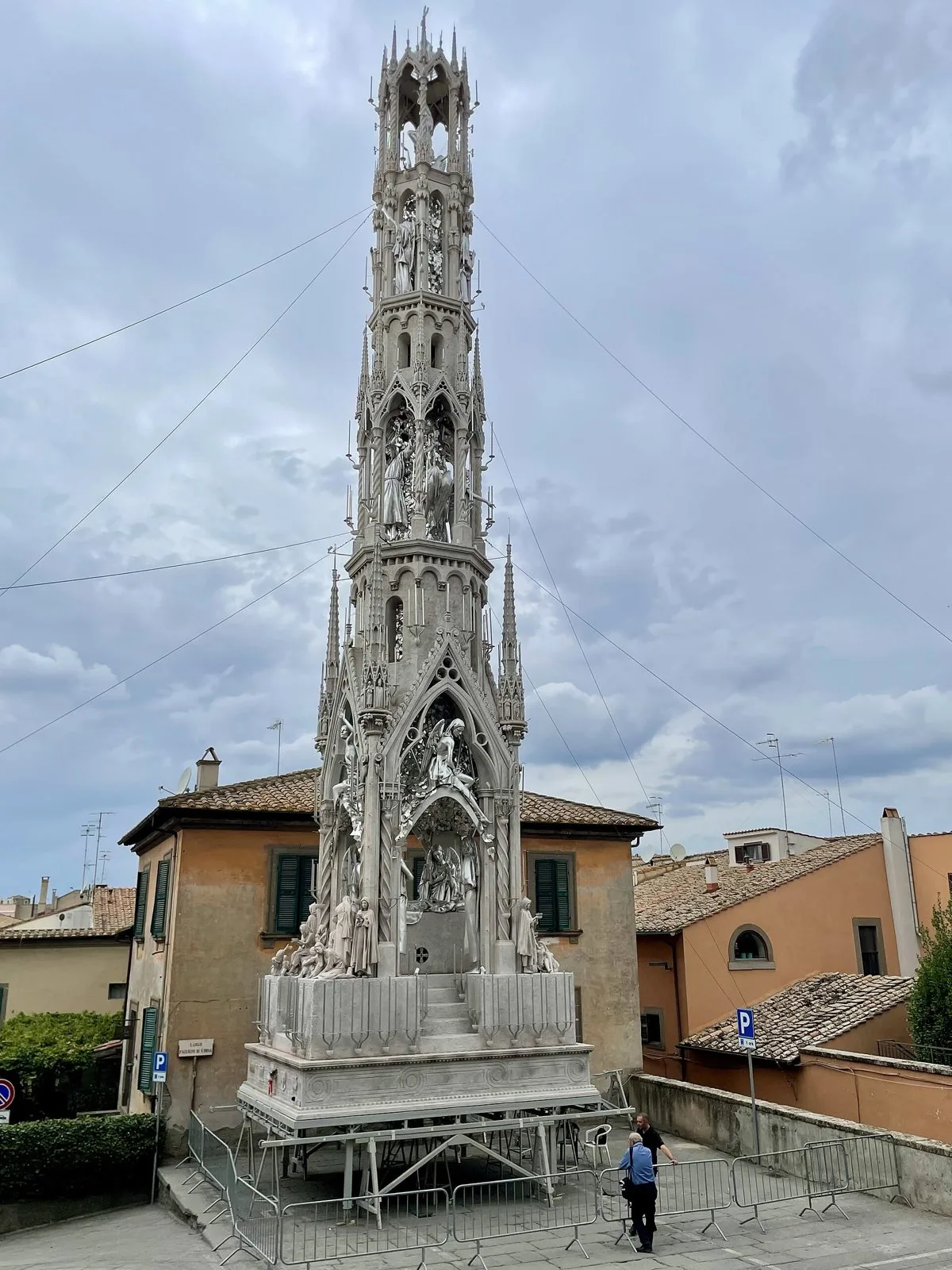 La Macchina di Santa Rosa esposta a Viterbo, un'alta torre bianca e argento decorata con statue e guglie, tra case dai tetti in coppi