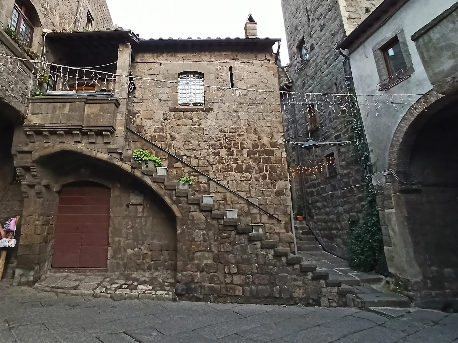 Una casa medievale in pietra nel quartiere San Pellegrino di Viterbo con il tipico profferlo, la scala esterna che sale al ballatoio su un arco